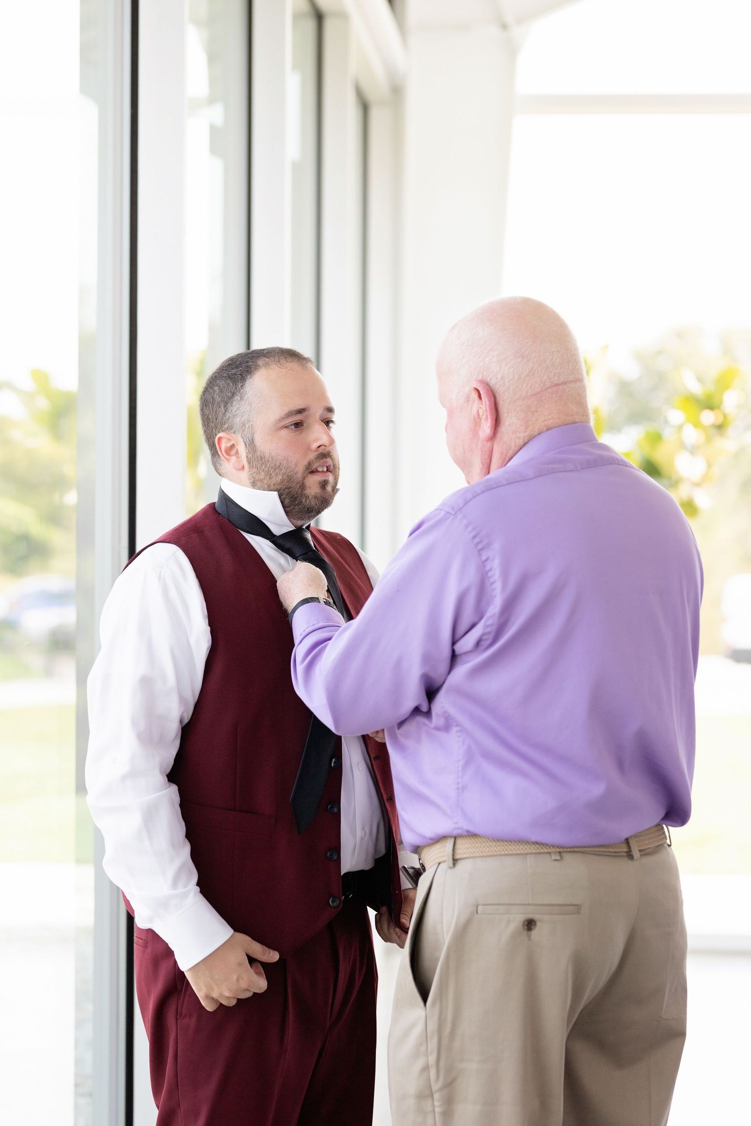 Grandpa helps groom with tie