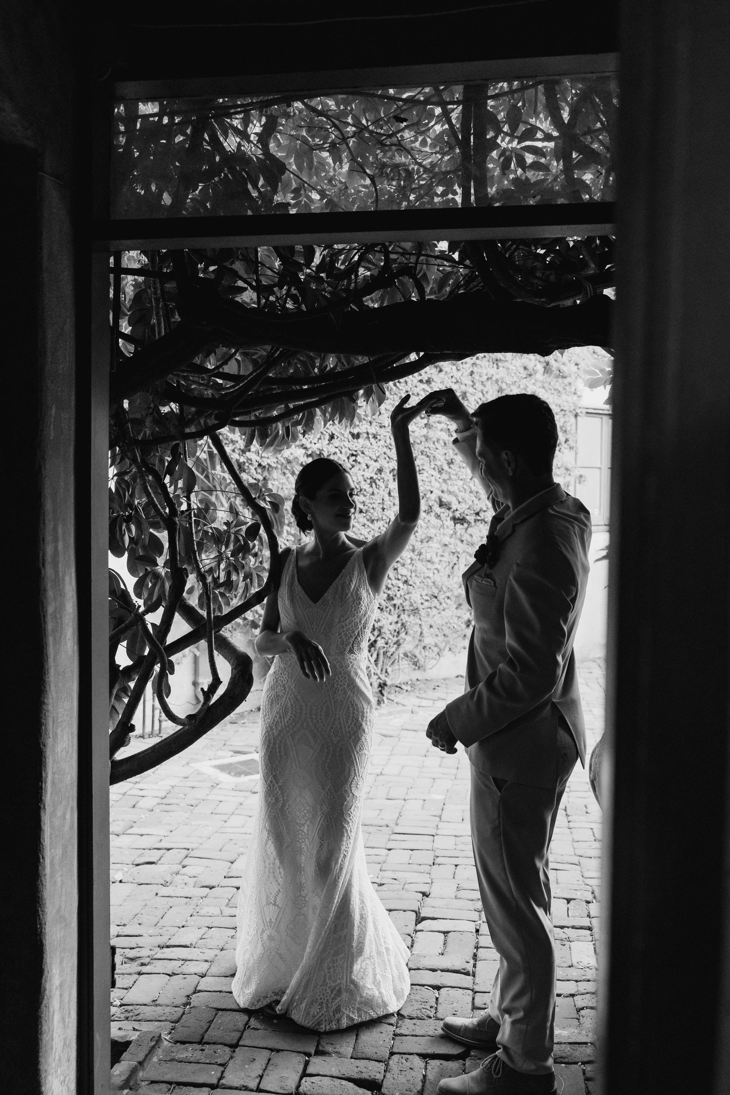 Black and white silhouettes of wedding party members posing against a stone wall.