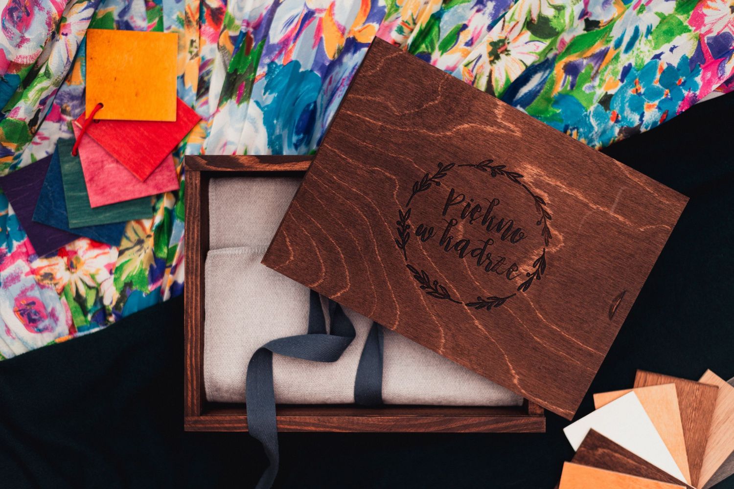 Colorful floral pattern fabric displayed alongside leather photo album materials.