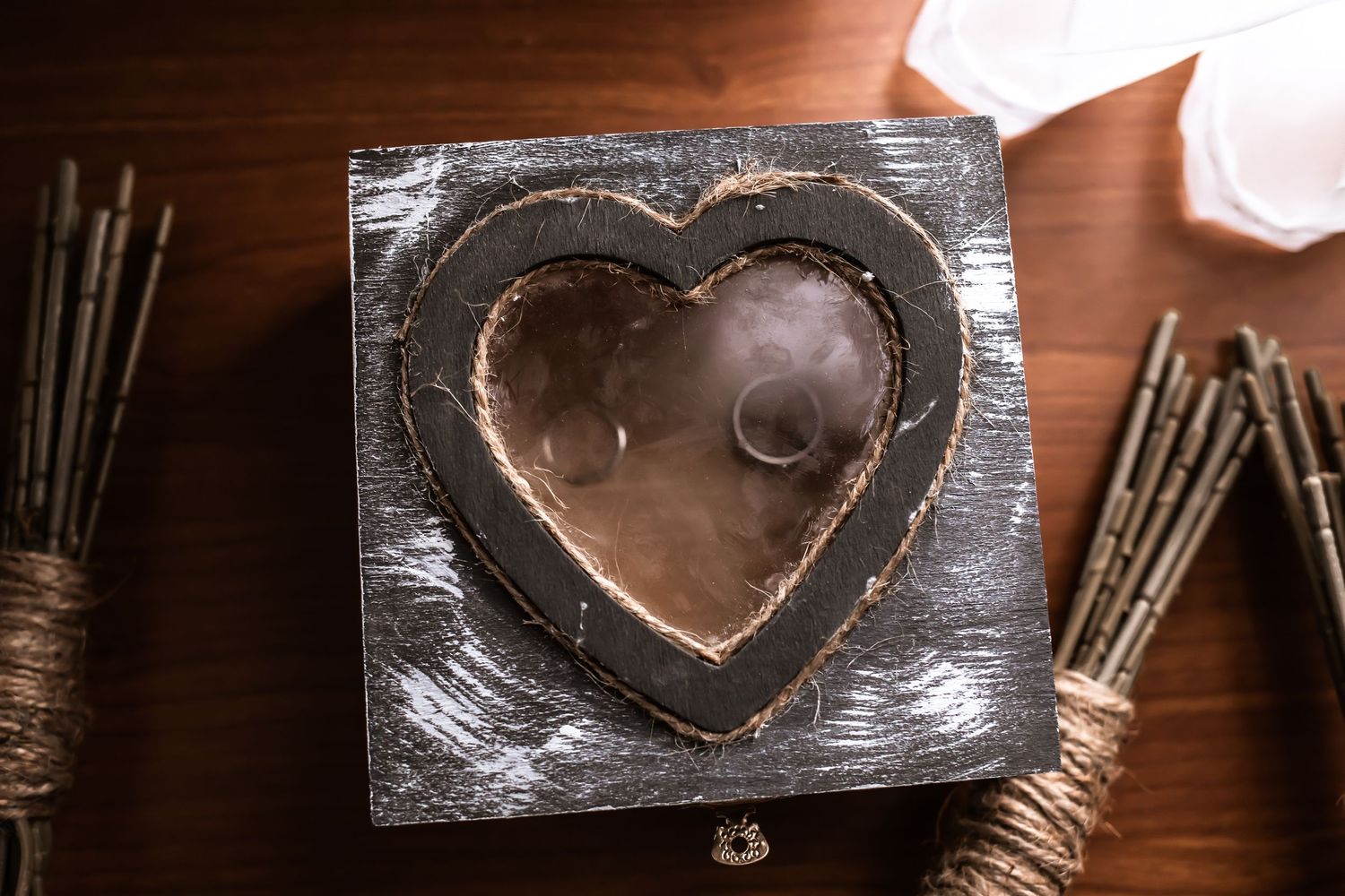 Rustic wooden heart-shaped box with decorative elements on a wooden surface.