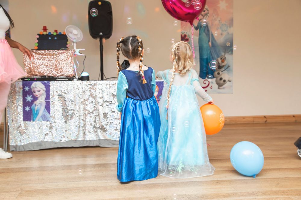 Young girls playing with bubbled at frozen themed birthday party