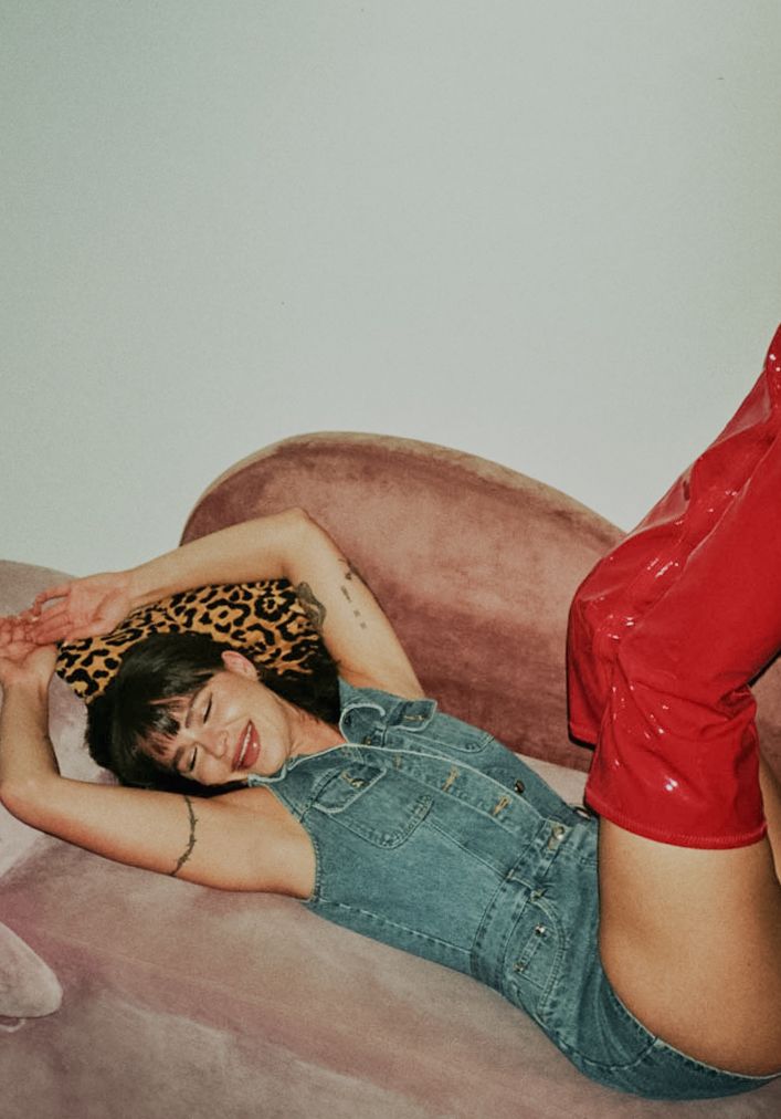 35mm film fashion portrait of woman in her home dressed in jean jumper red boots