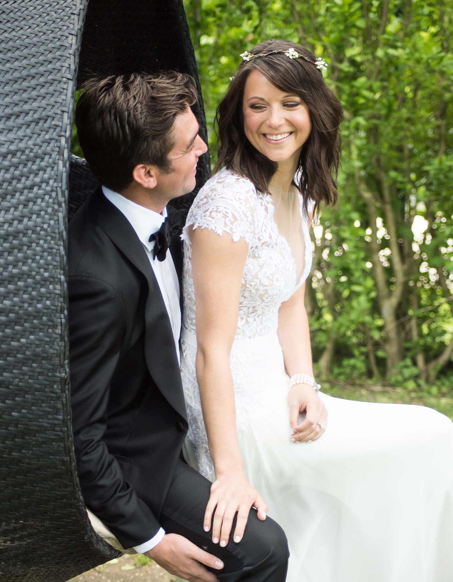 Intimate portrait of a couple sharing a sweet moment against a natural green backdrop.