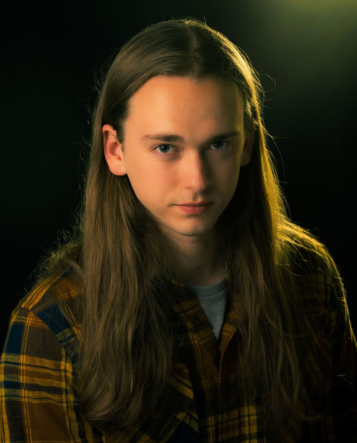Sheldon Hall with long hair and golden light in a headshot