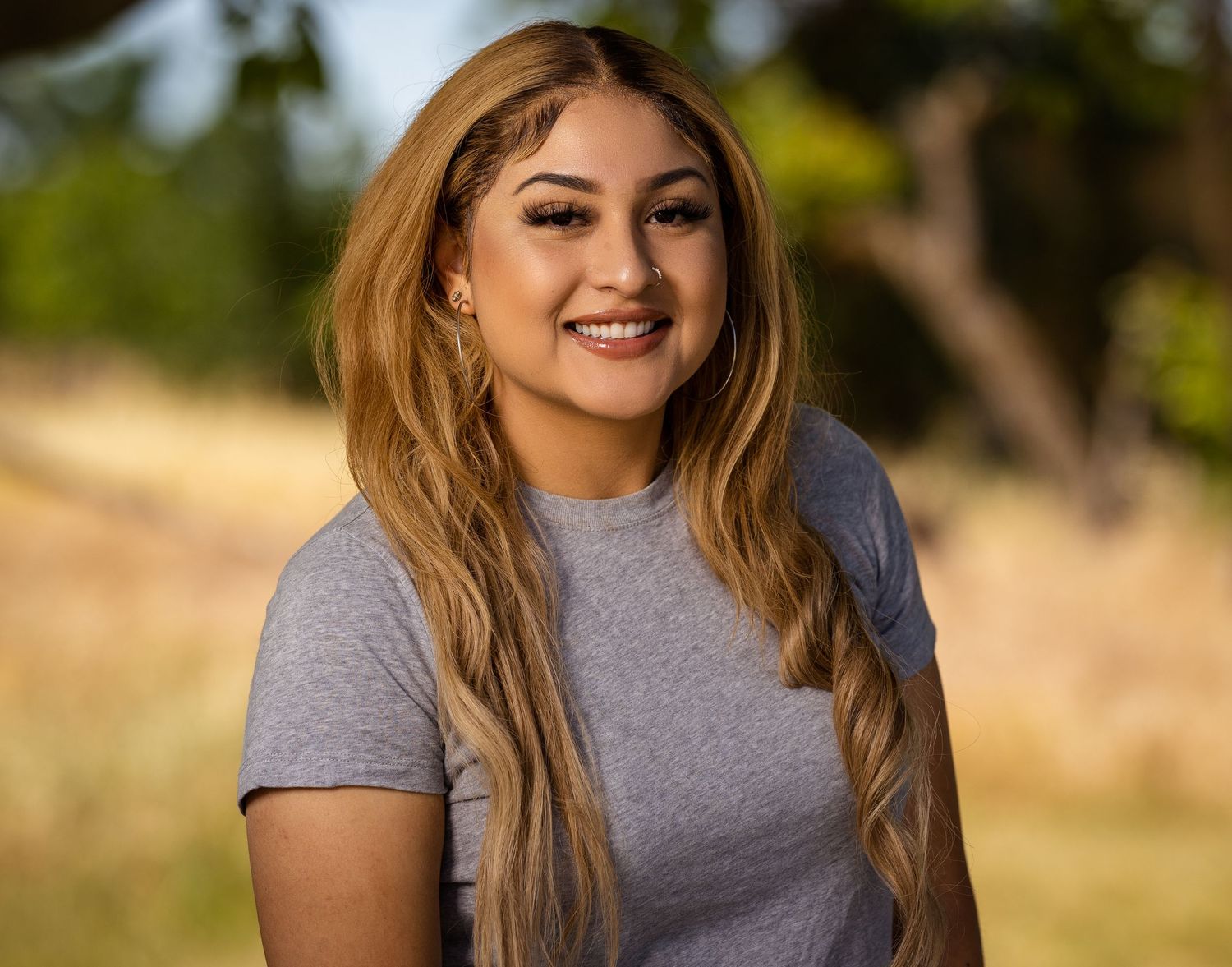 Headshot of a latina woman in grey t shirt outdoors