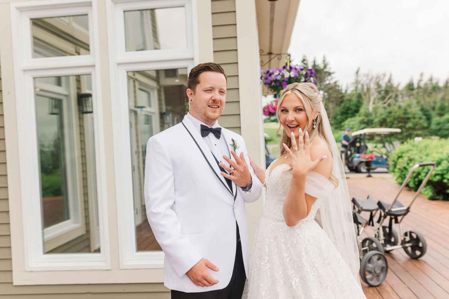 Outdoor wedding celebration with guests on patio of elegant venue with white columns.
