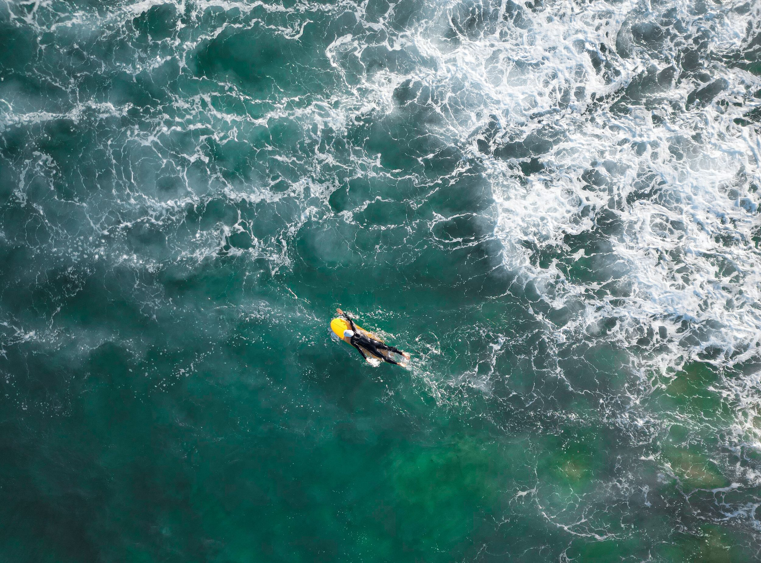 drone shot of surfer in the ocean top shot