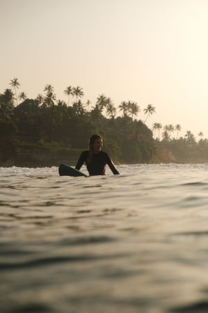surfer girl on board sunrise in the ocean happy