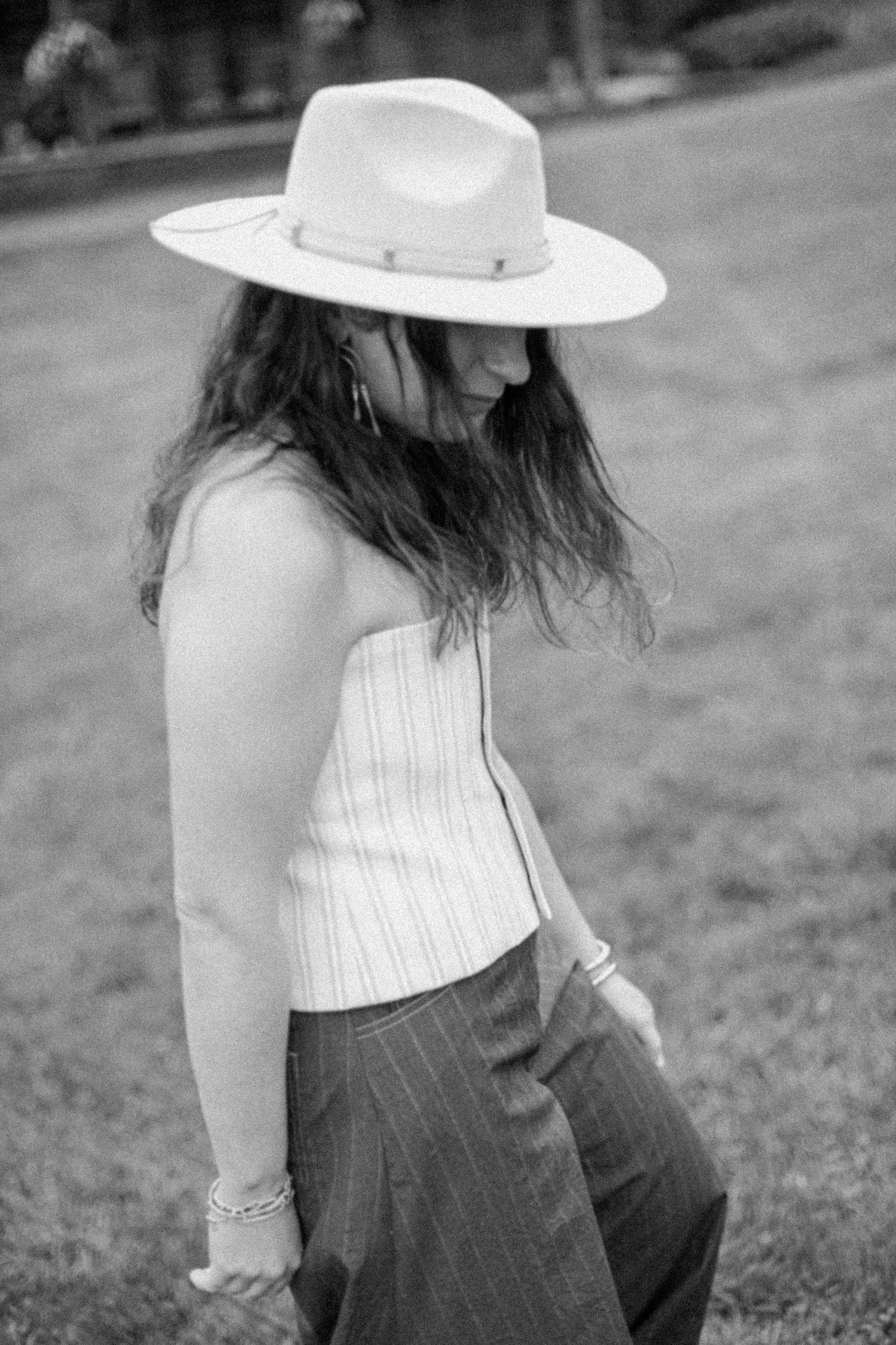 Casual summer outfit featuring white corset top, striped pants and wide-brim hat in black and white.