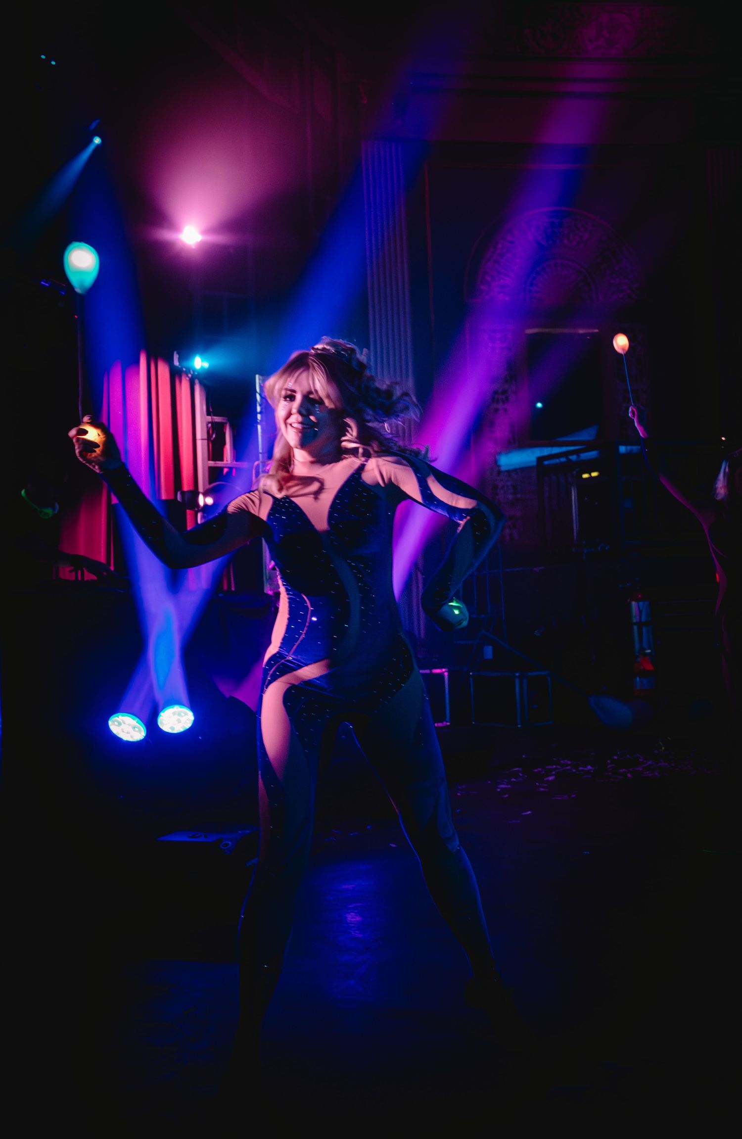 Dramatic dance performance with purple and blue stage lighting creating a moody atmosphere.