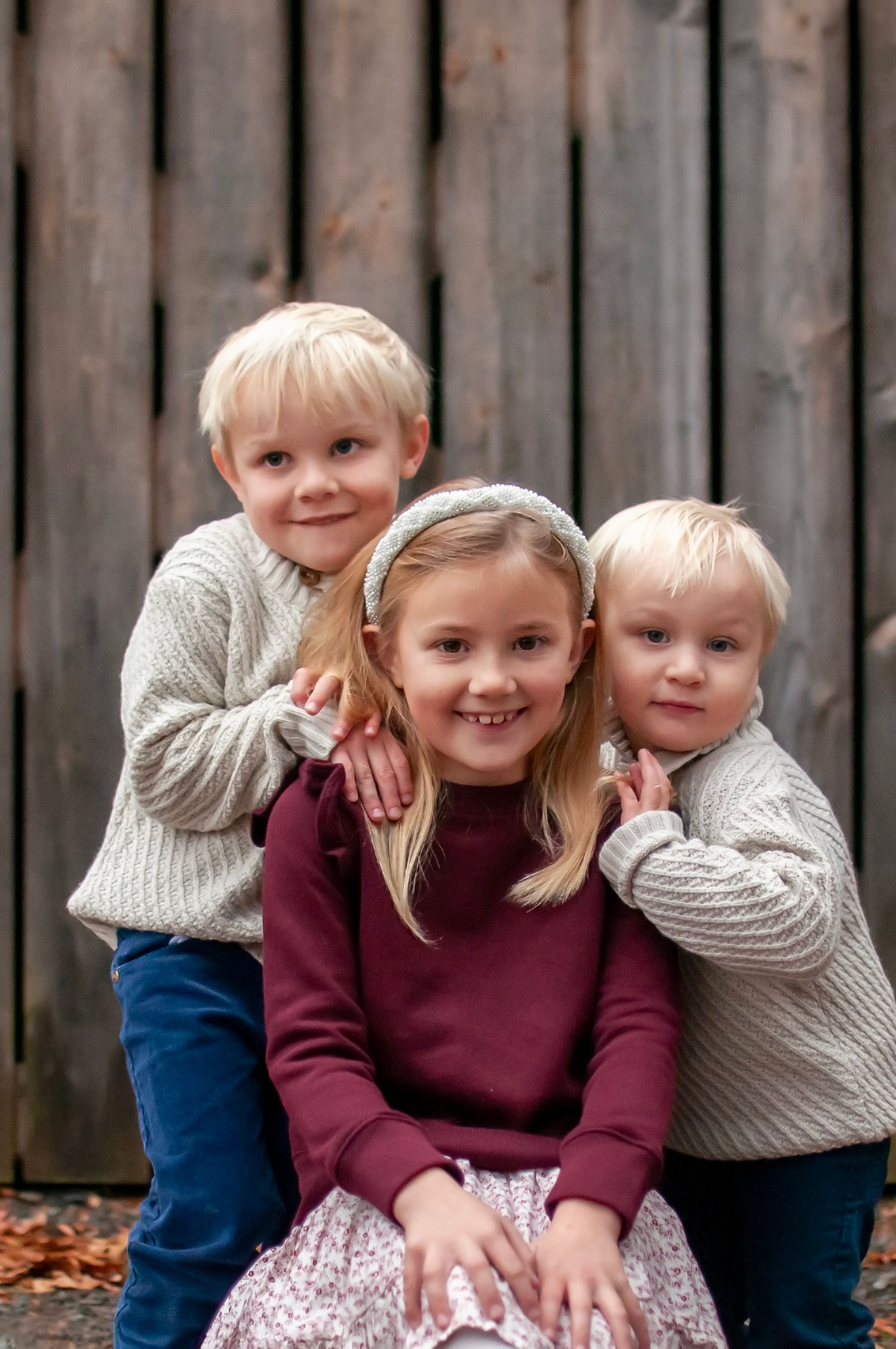 Three young kids near gray barn at Claude Moore Park