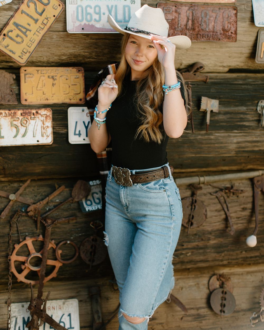 Rustic portrait against vintage license plates and wooden wall background.