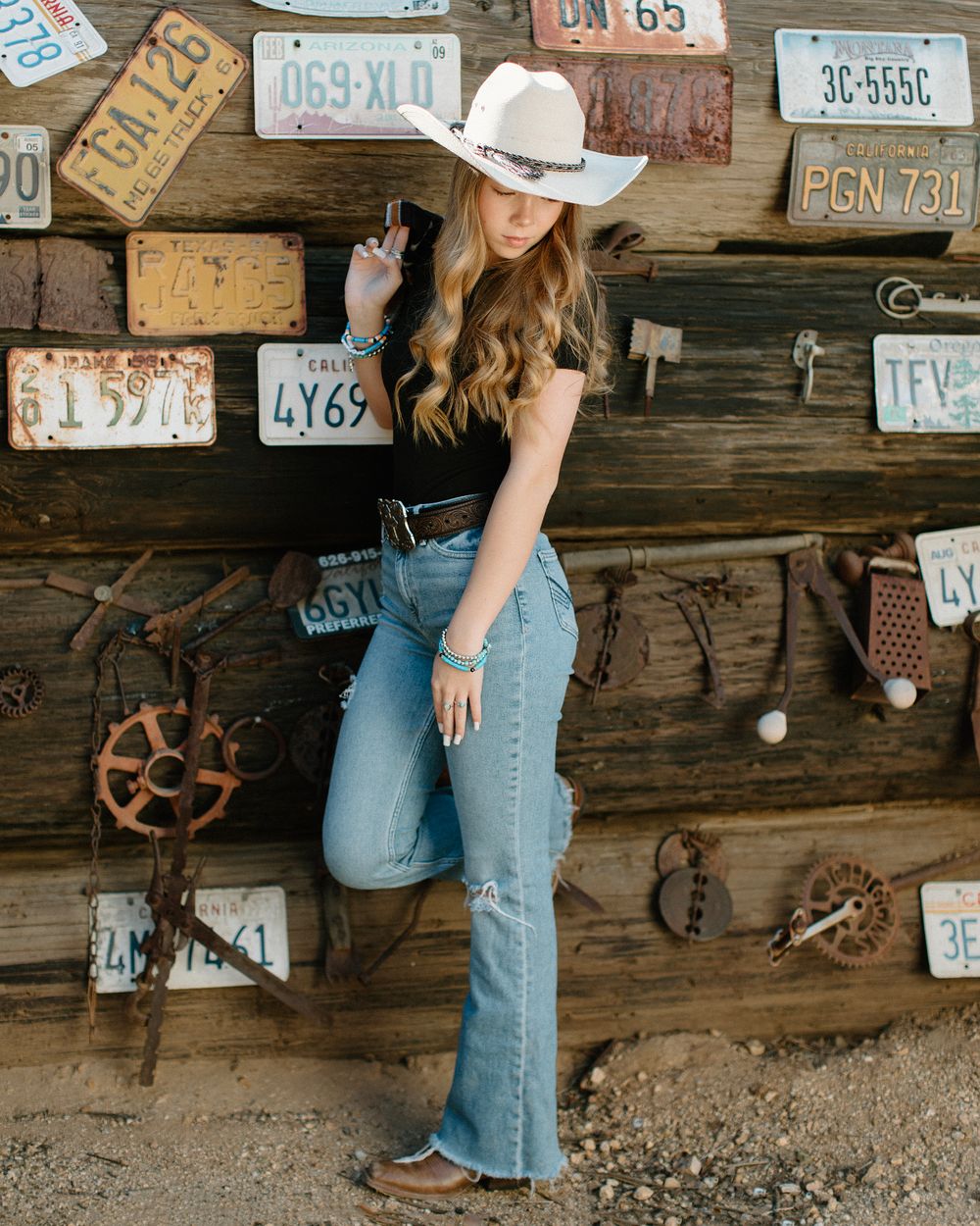 Casual western style portrait with vintage license plates and rustic decor.
