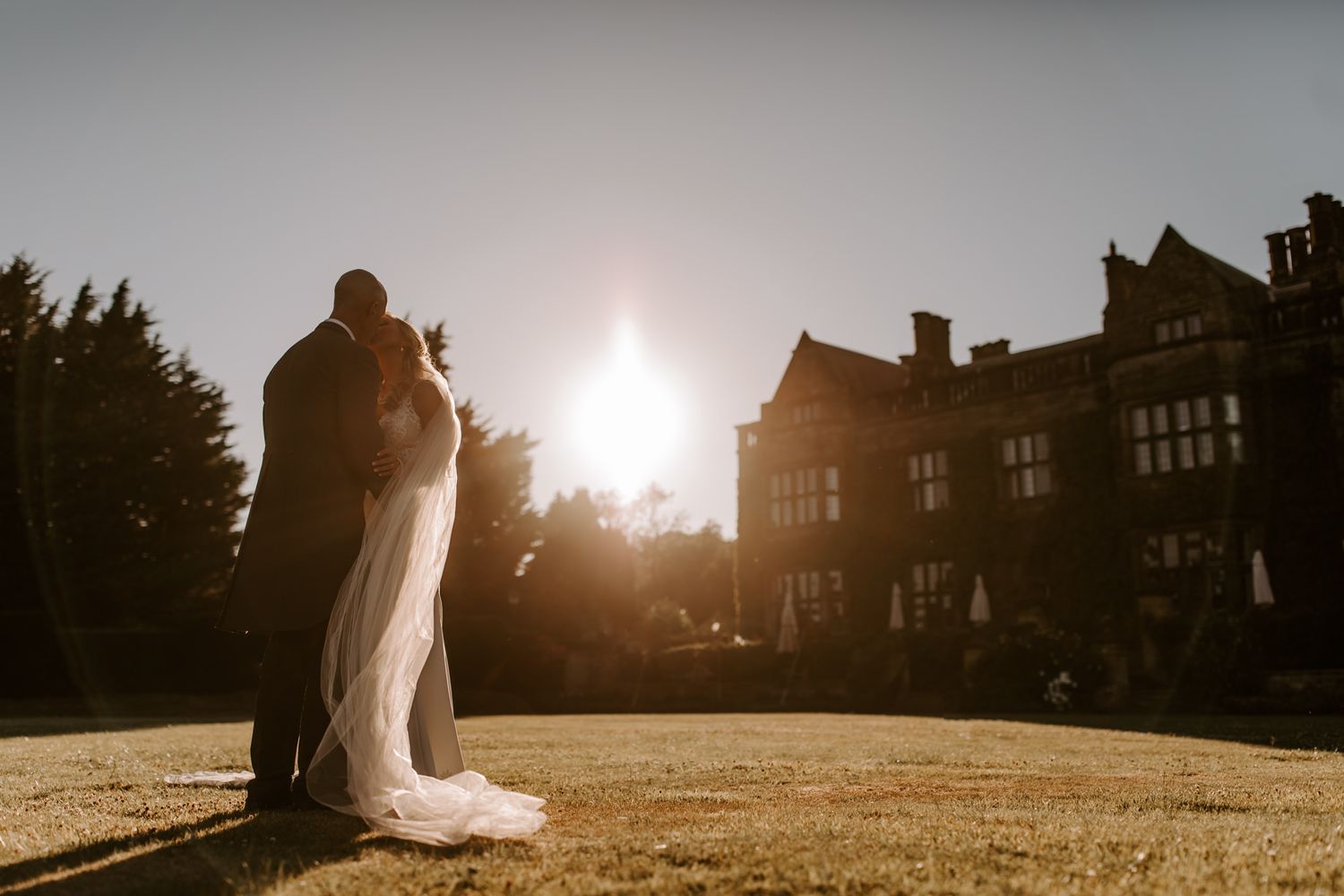 Couple at sunset kissing on front lawn