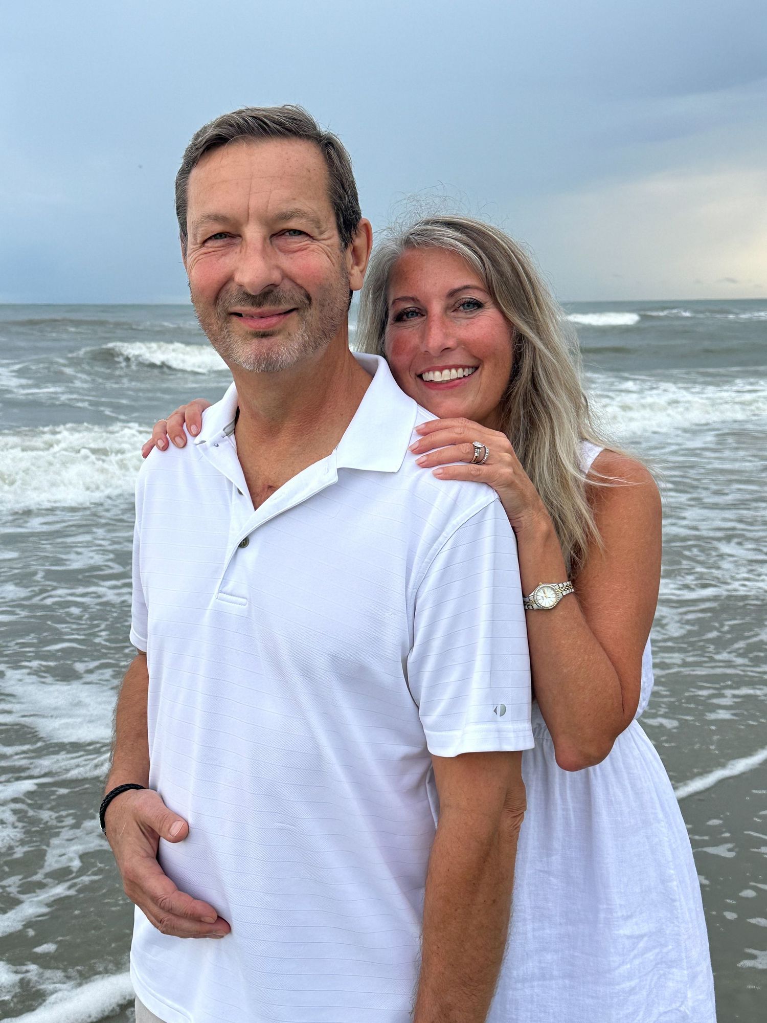 A couple sharing a tender moment at the beach during sunset.
