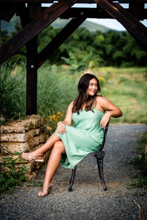 Garden portrait featuring mint green sundress and decorative wooden pergola backdrop.