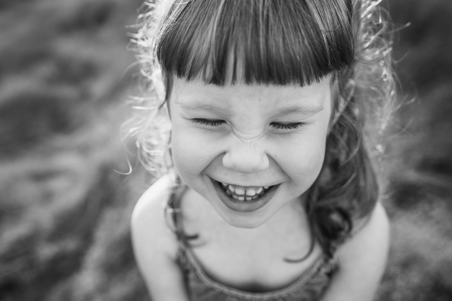 Black and white portrait of girl scrunching her nose.