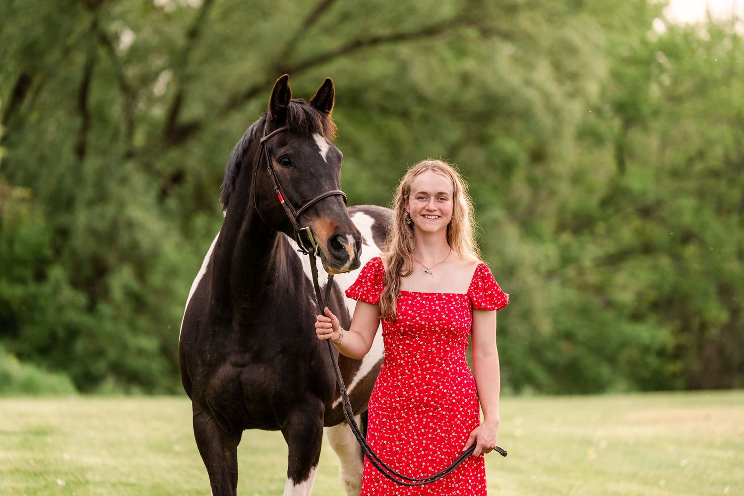 Girl in a bright red dress with a black and white paint horse