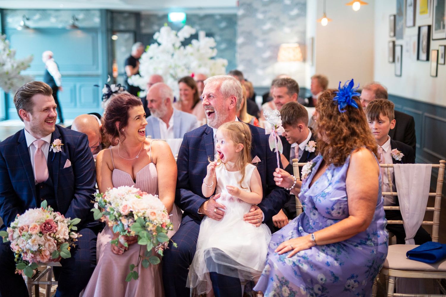 Wedding reception guests laughing and enjoying themselves at elegantly decorated tables during dinner.