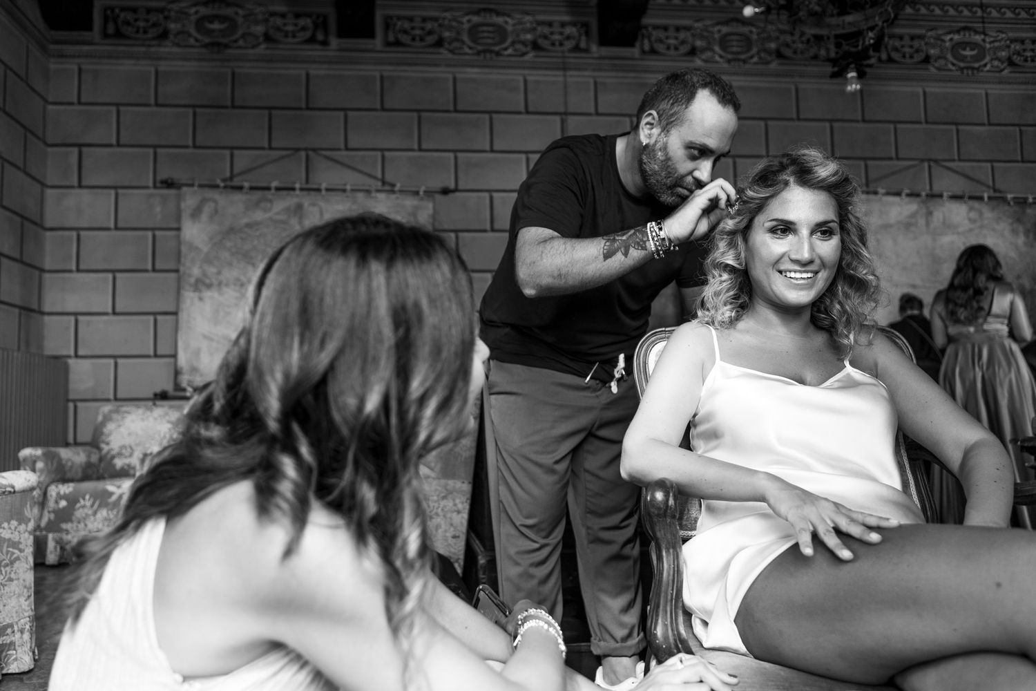 Black and white behind-the-scenes image of a styling session with multiple people.
