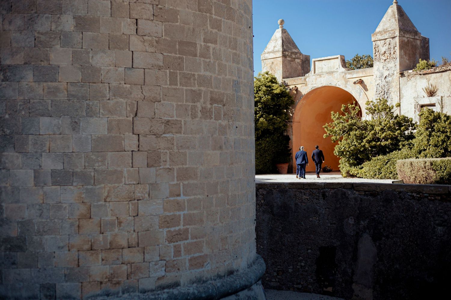 Stone castle walls and archways frame a scenic destination wedding venue.
