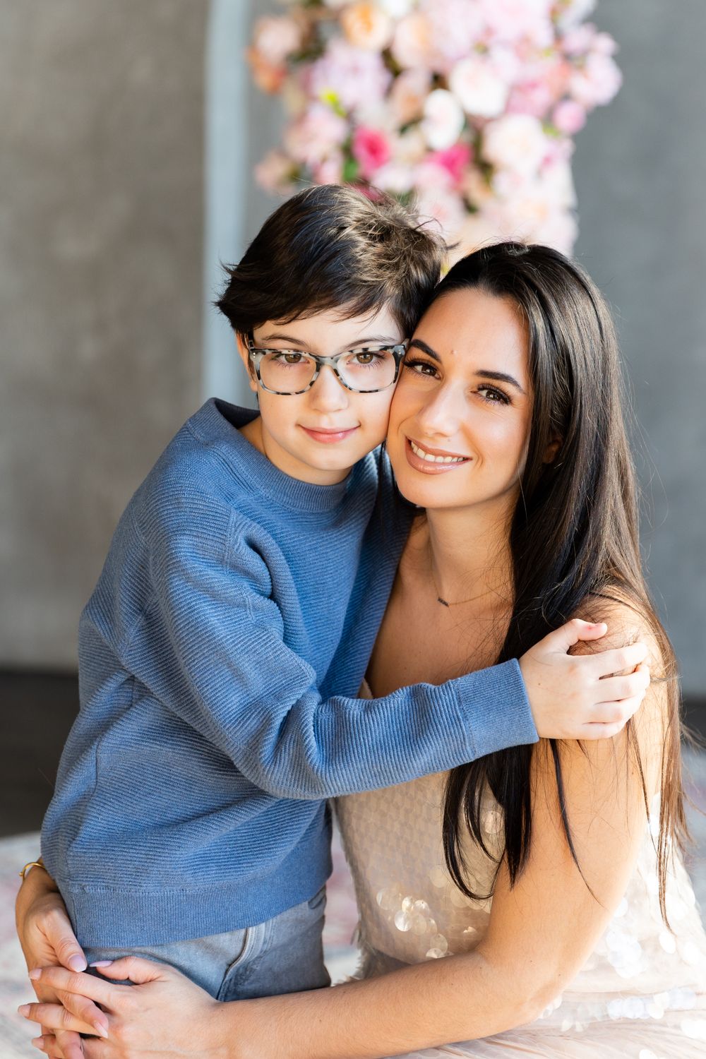 Mother and young son photography session for mother's day at Mint Room Studio with floral setup.