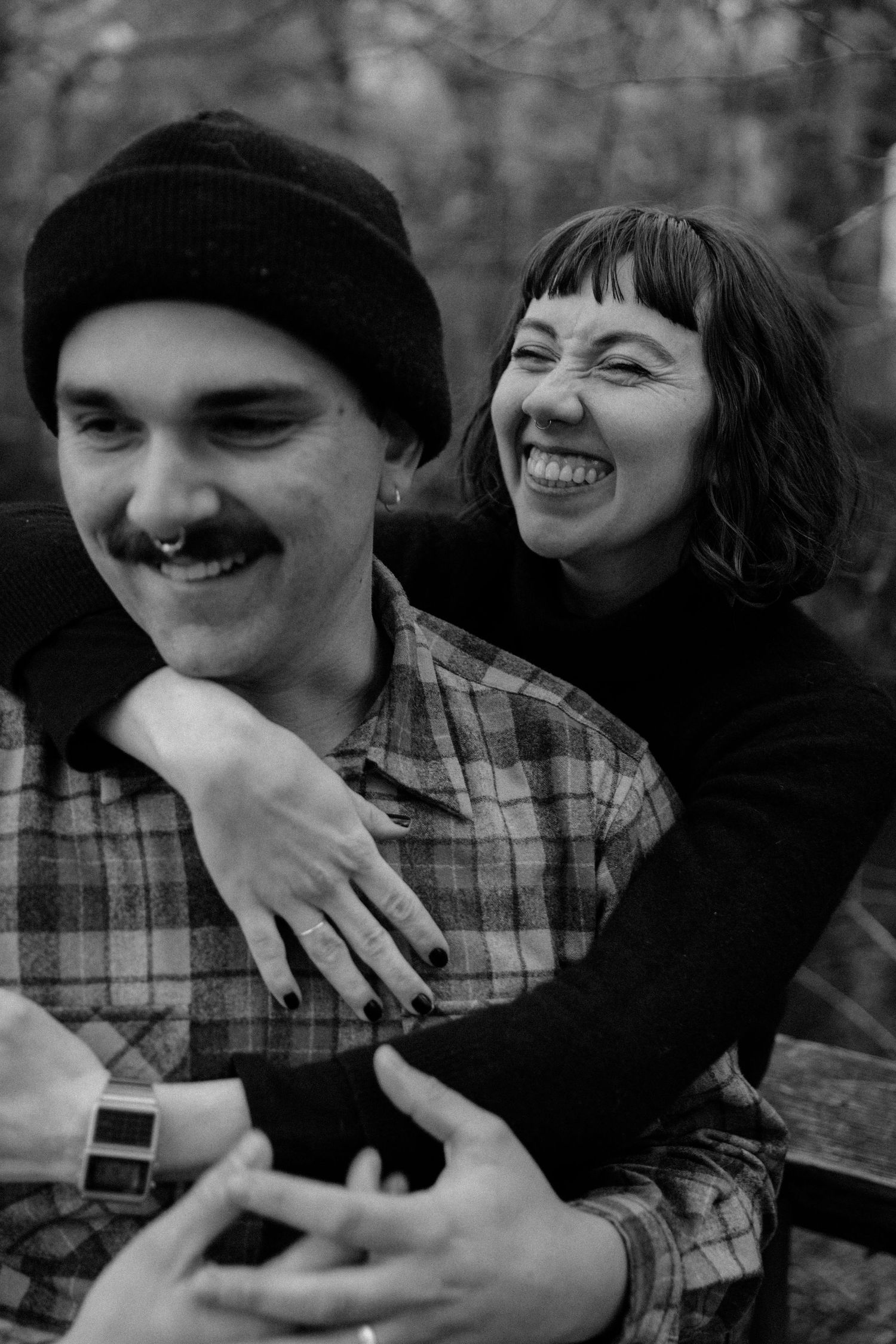 A joyful candid moment captured in black and white showing a playful embrace.