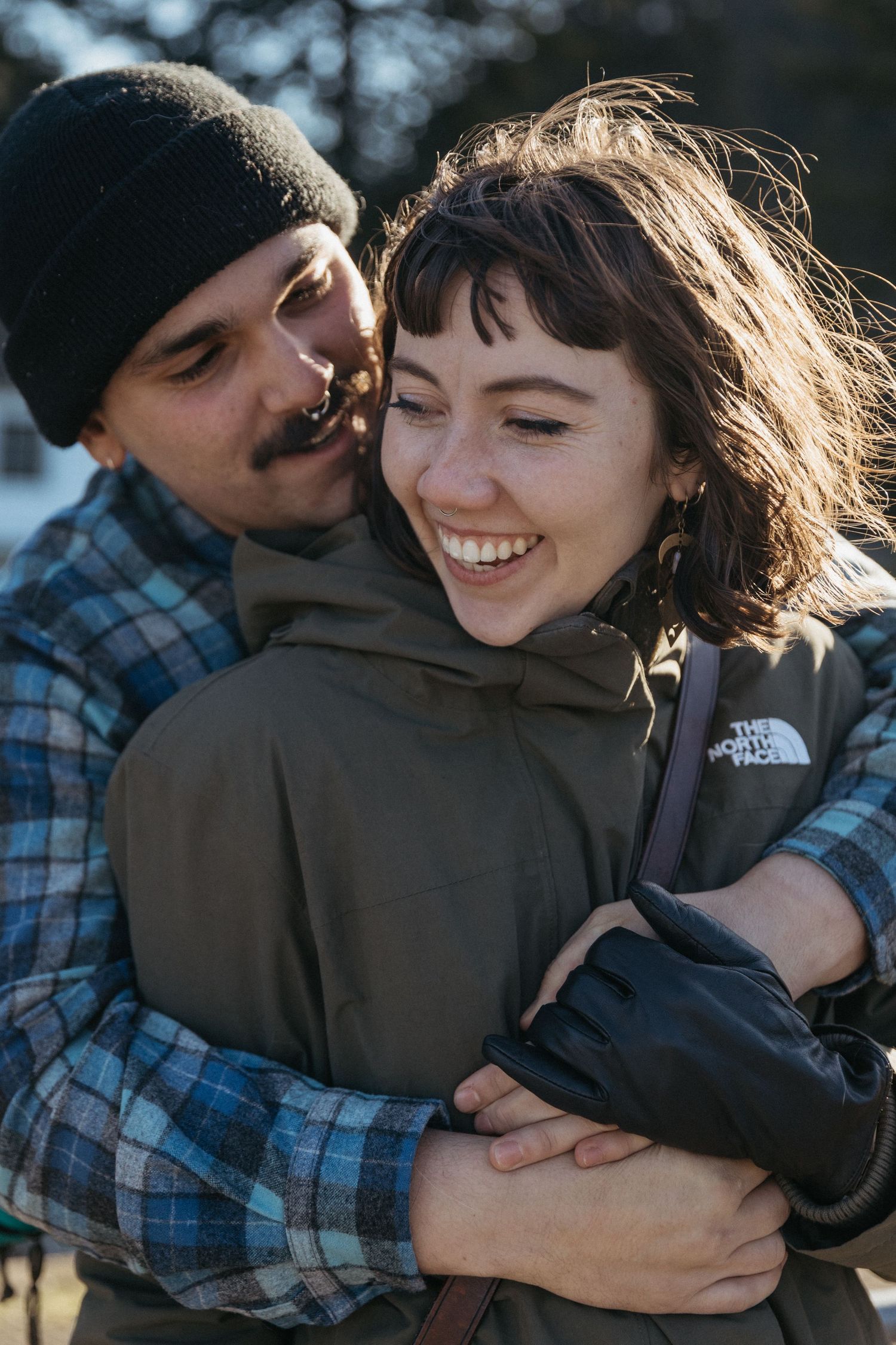 Cozy winter portrait of a couple embracing outdoors in warm clothing.