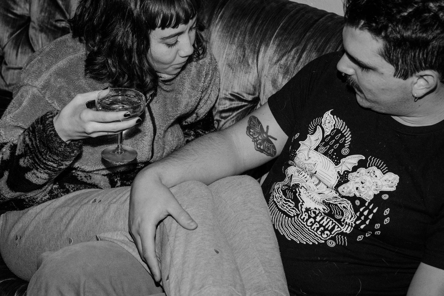 Black and white photo of intimate moment shared on leather couch.