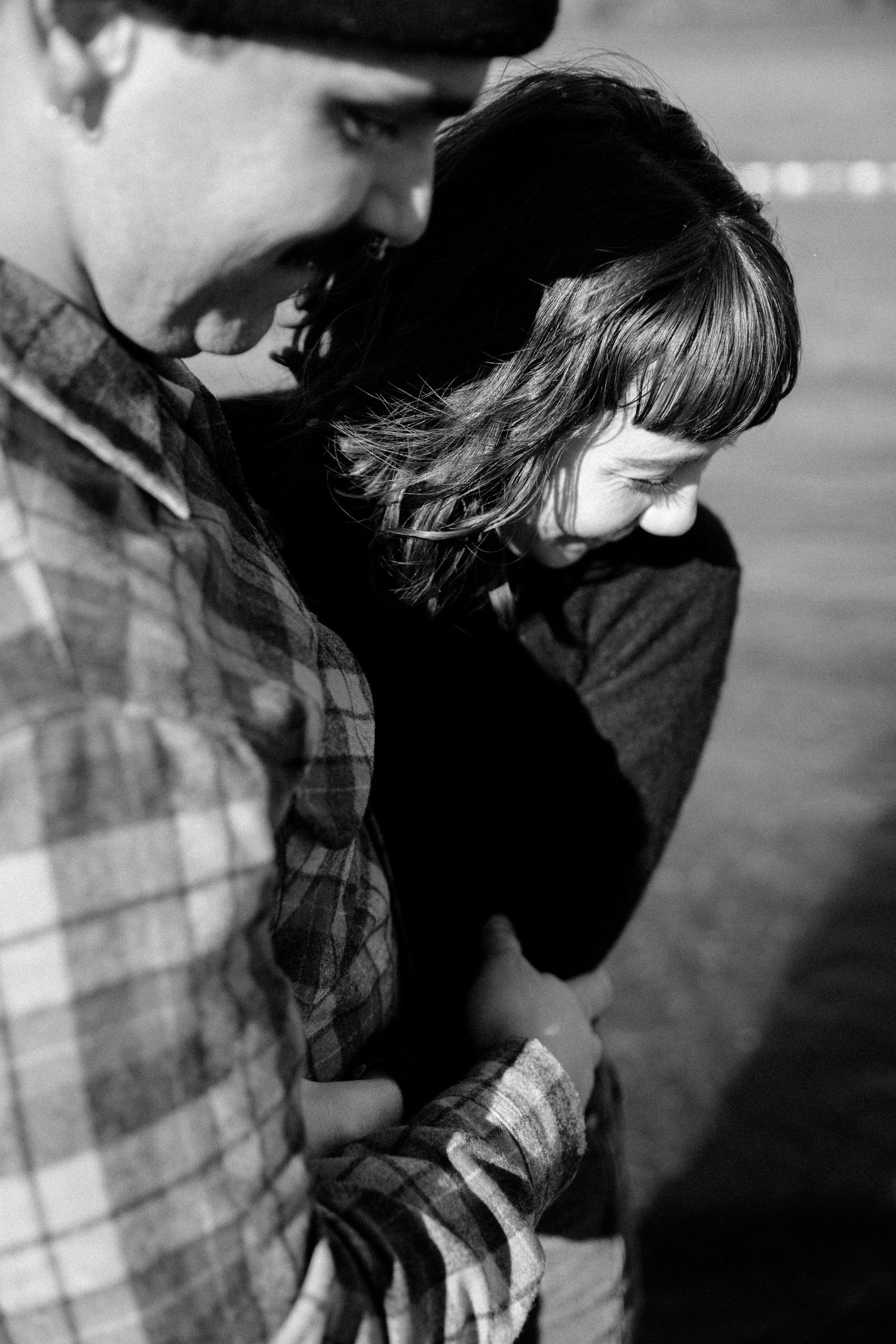 Intimate black and white portrait capturing a gentle moment between two people.