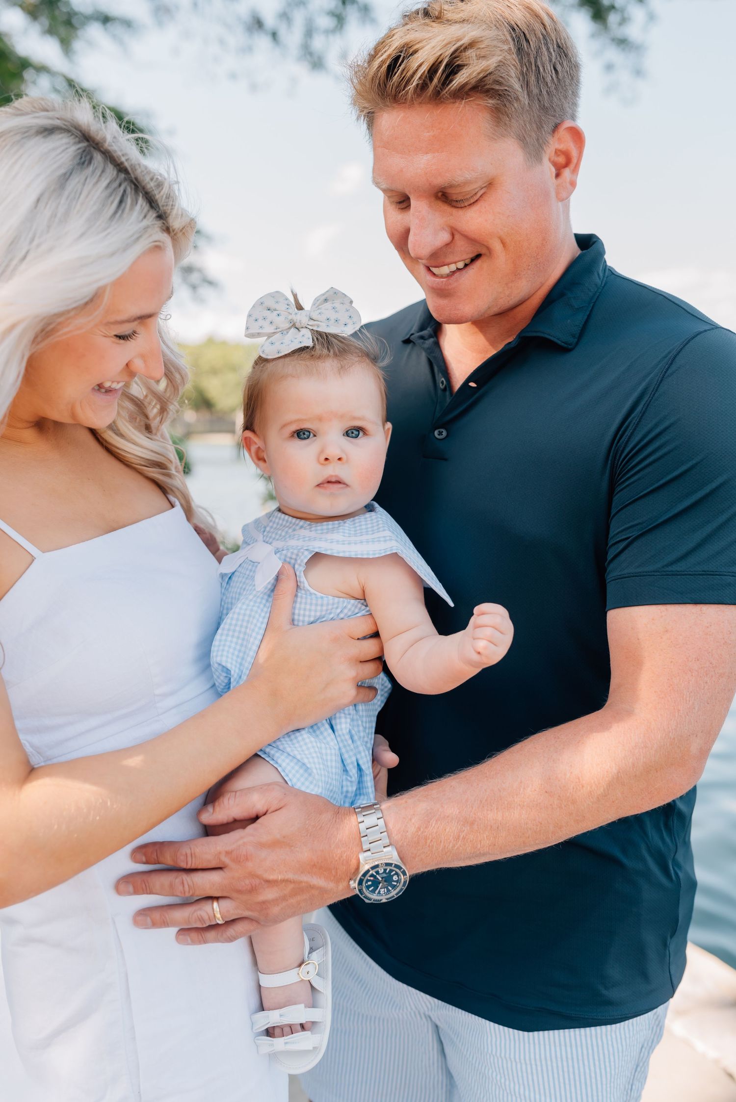 A couple smiles at their daughter.