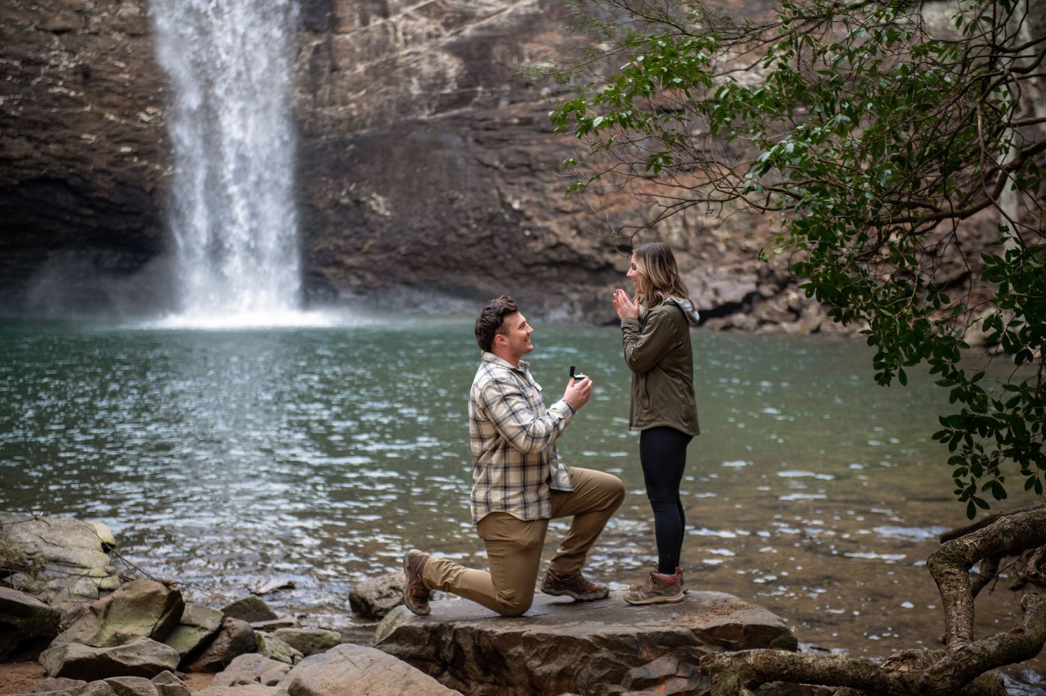 A scenic proposal sequence at a picturesque waterfall surrounded by rocky terrain.