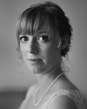 Classic black and white bridal portrait showing elegant makeup and pearl necklace.