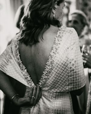 Back view of textured wedding dress with intricate beaded details along V-shaped neckline.