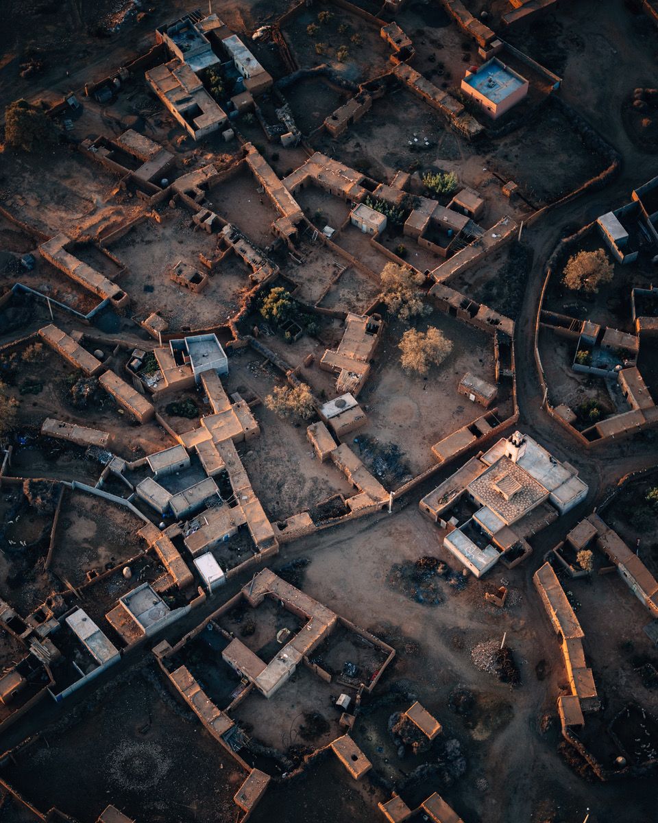 Aerial view of traditional village buildings and winding streets at dusk.