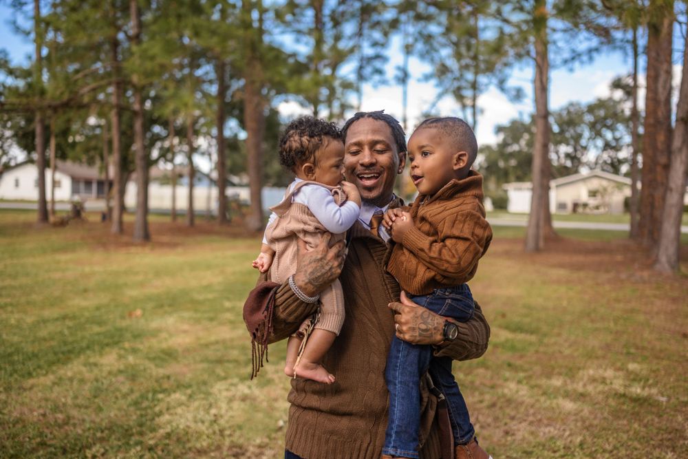 A heartwarming embrace between family members in a sunny pine forest.