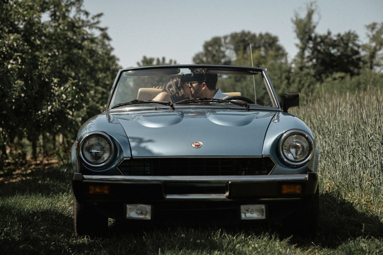 Classic convertible sports car photographed in profile against a natural landscape.