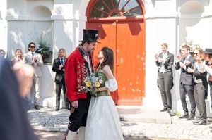 Lyckan för ett nygift par utanför kyrkan tillsammans med nära och kära