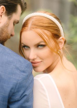 An intimate wedding portrait capturing tender moment between couple against soft natural background.