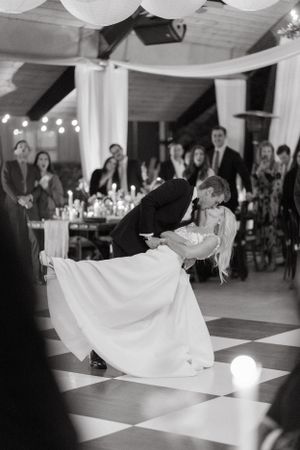 Black and white photo of dance floor with dramatic dip during wedding reception.