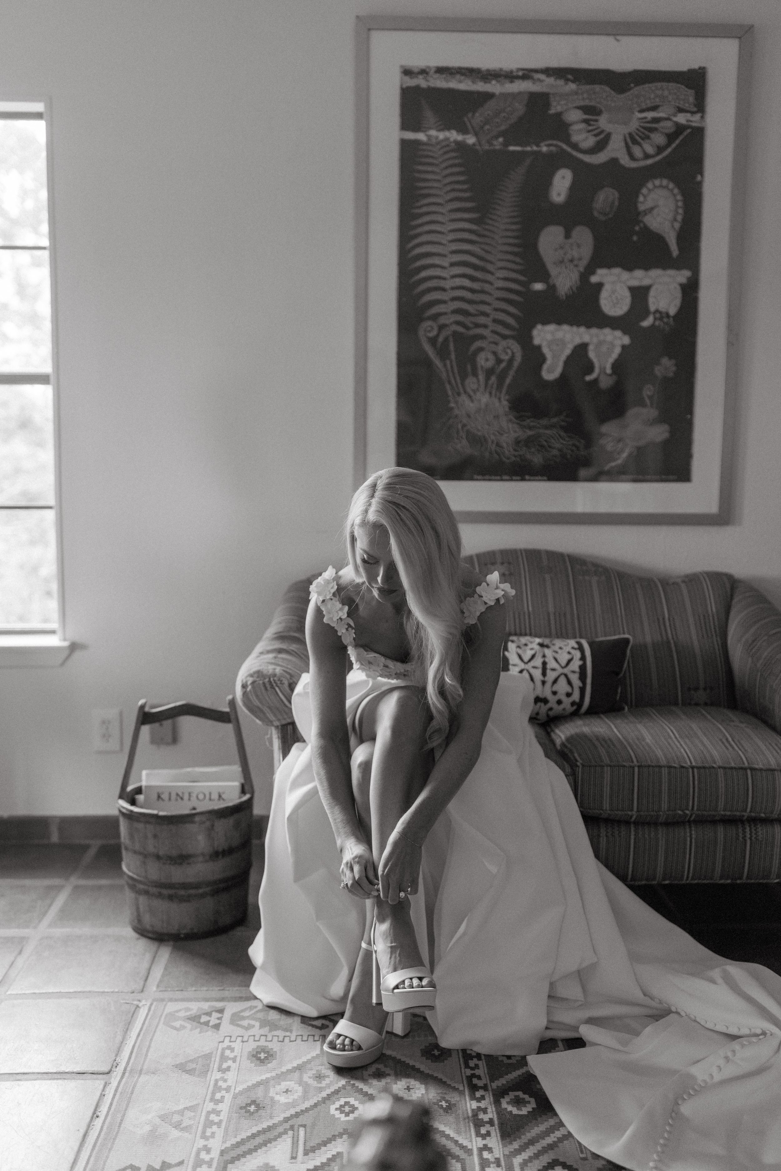 Wedding dress preparation scene in minimalist room with couch and artwork.