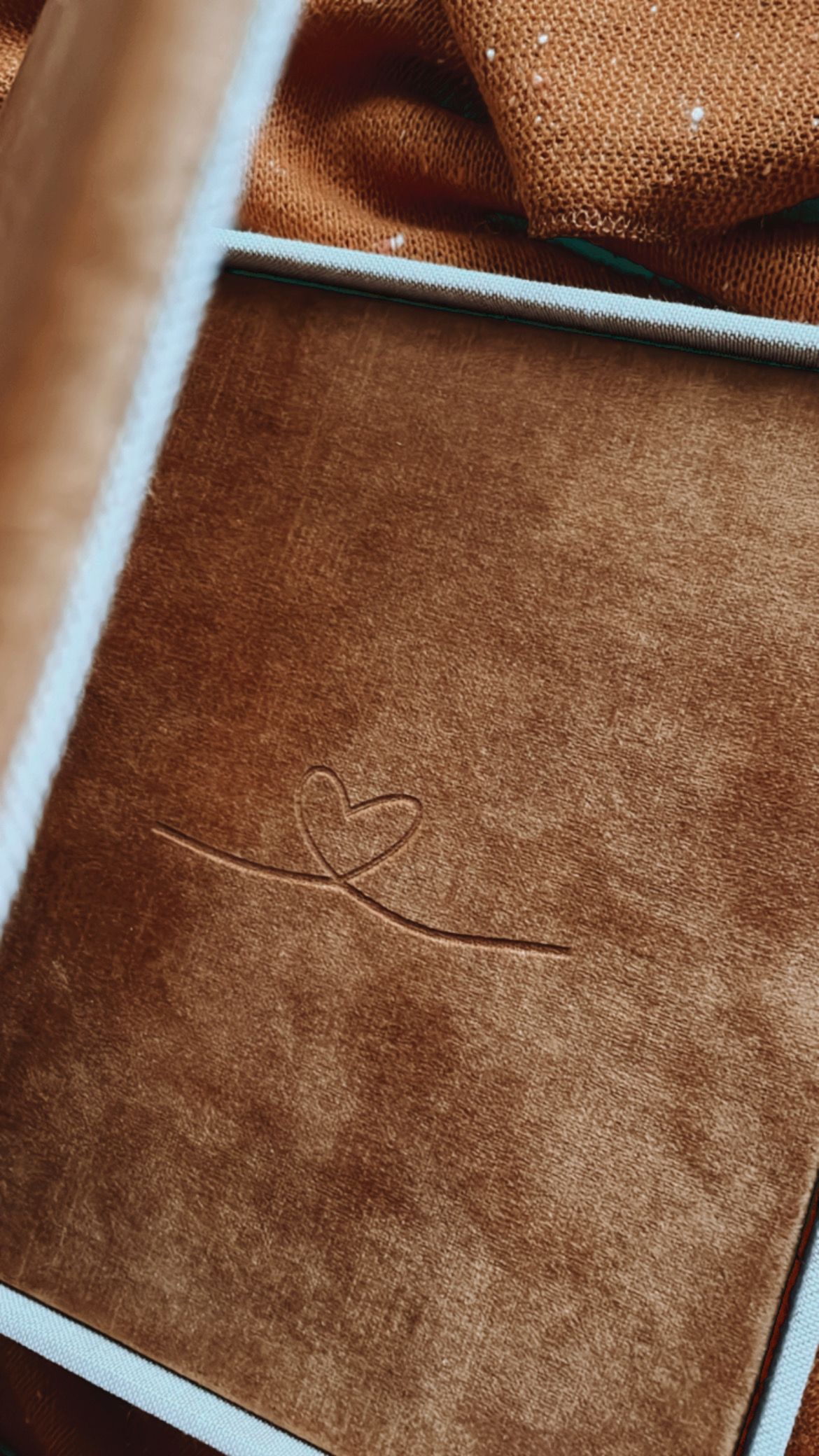 Brown velvet book cover with embossed heart design detail.