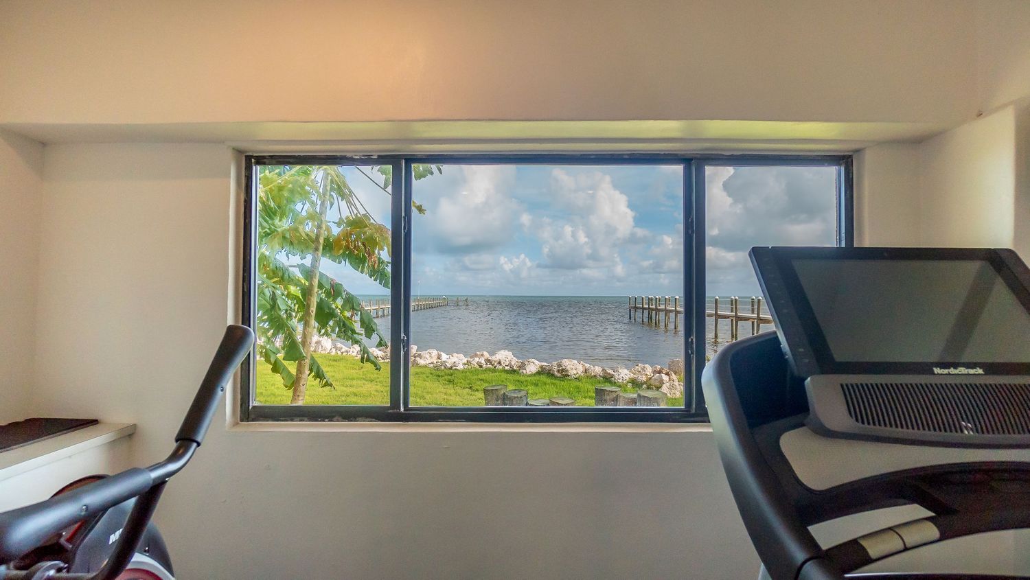 Large window with ocean view in modern apartment interior.