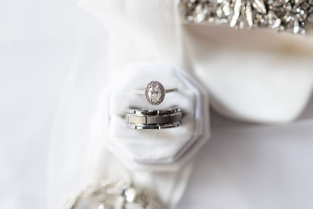 Close-up of wedding rings displayed in white octagonal ring box.