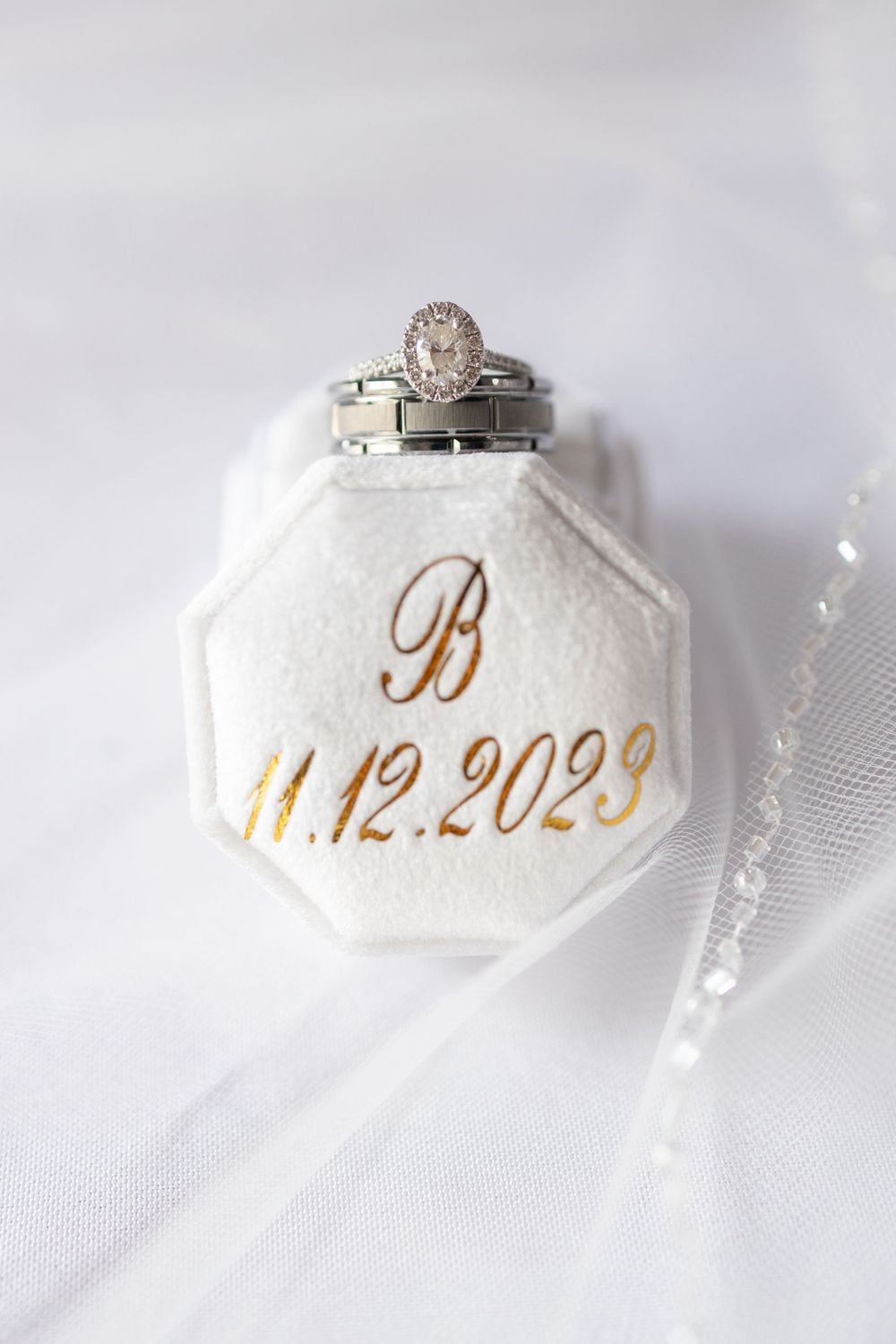 Wedding rings displayed on white octagonal ring box with date inscription 11.12.2023.