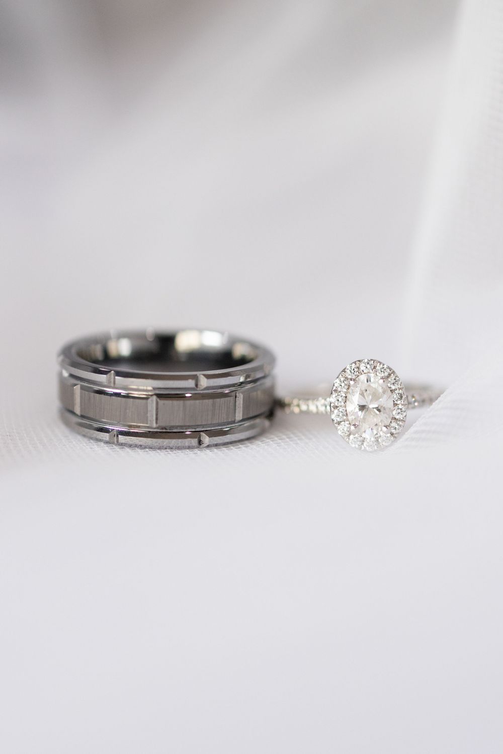 Elegant wedding rings featuring a diamond engagement ring and textured metal band on white background.