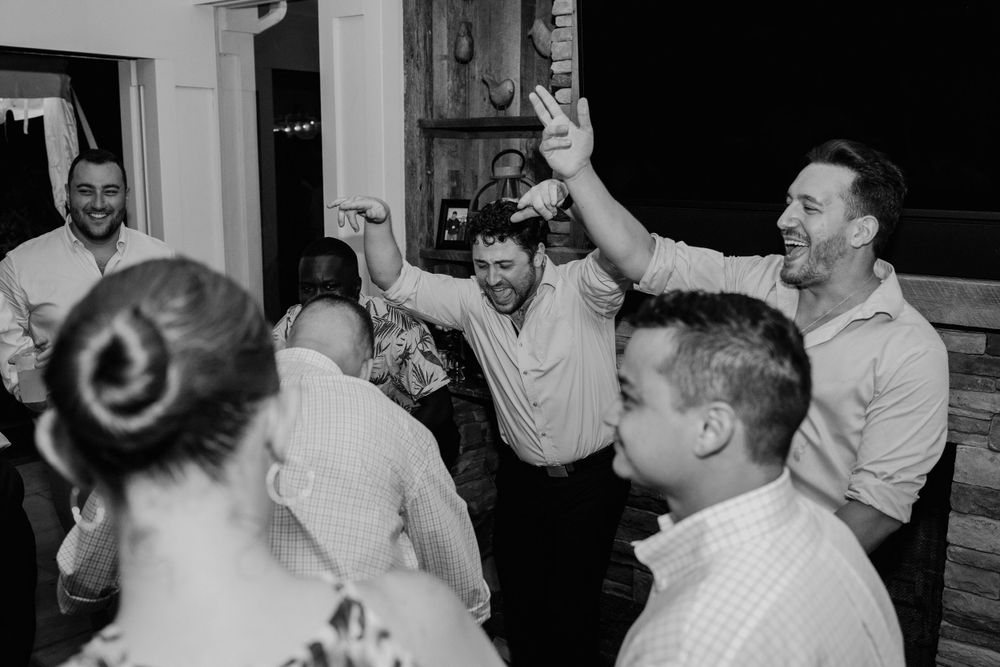 A lively celebration with people dancing and cheering at an indoor party.