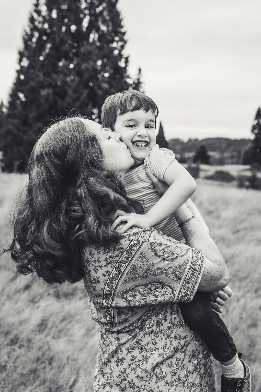 Black and white photo of mom kissing her son