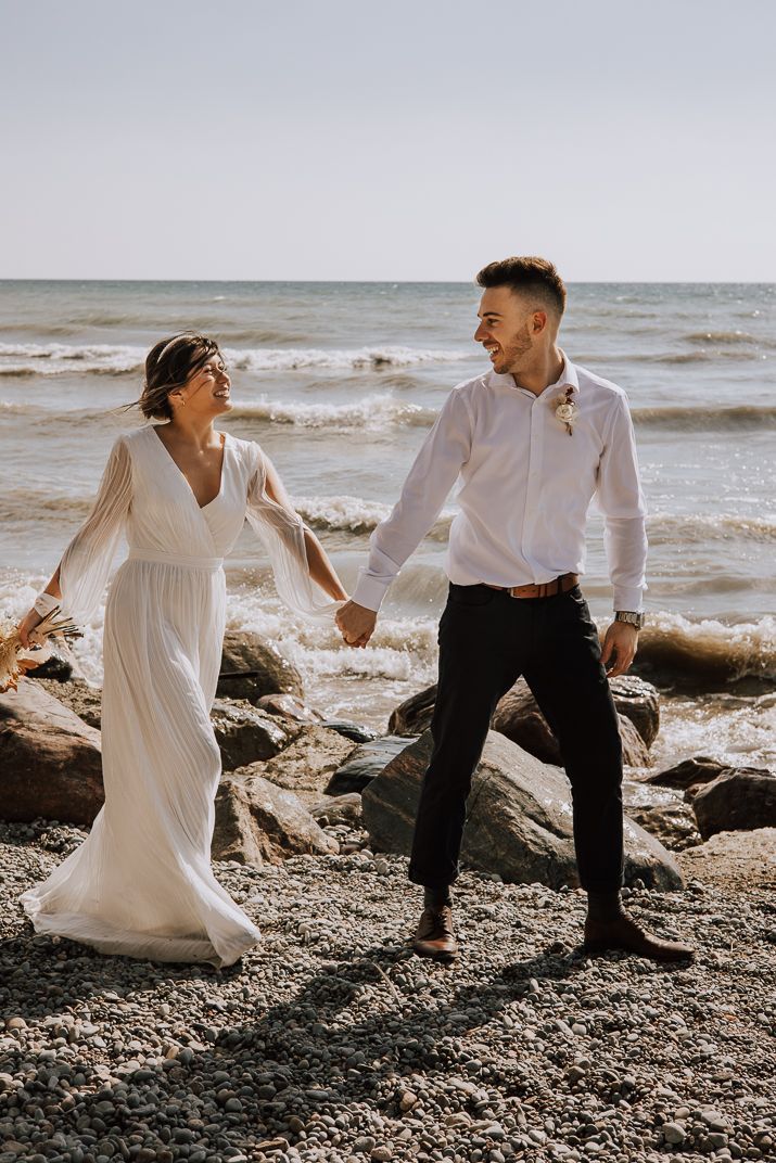 Bride and Groom stroll on the shores of lake Ontario in Oshawa in their elopement day.