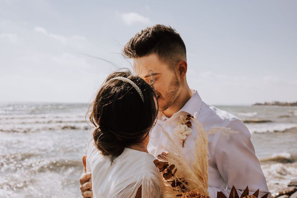 bride and groom kissing on their wedding day, beach front in Toronto.